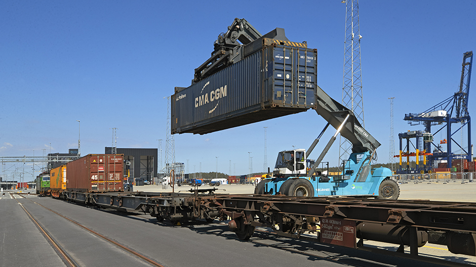 Container truck loading container onto train