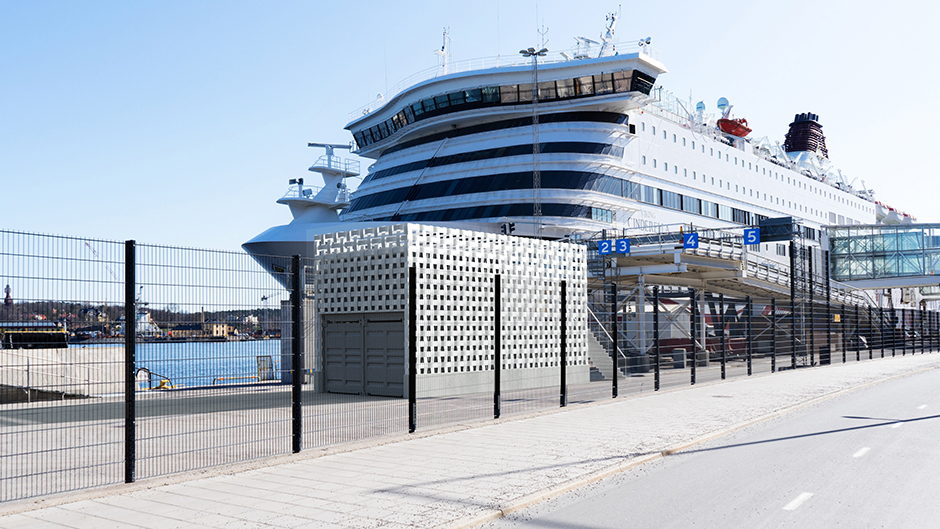 Onshore power connection building in front of a cruise ship
