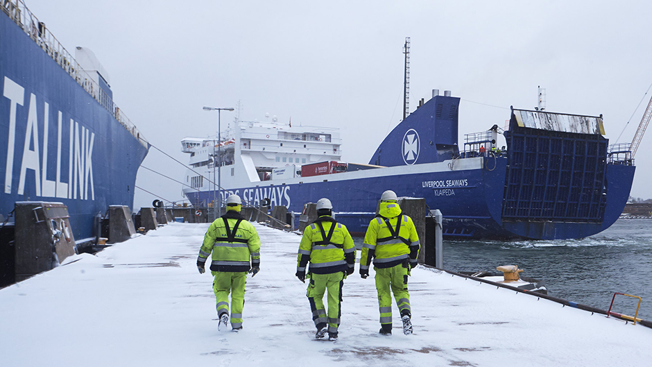 Three dockworkers in a snowy Port of Kapellskär
