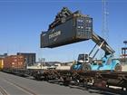 Container truck loading container onto train