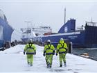 Three dockworkers in a snowy Port of Kapellskär